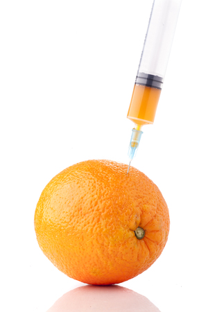Big orange with a syringe in it. Concept for GMO.の写真素材