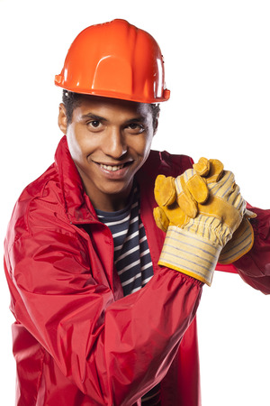 dark-skinned worker with helmet and gloves showing a gesture of congratulationsの写真素材