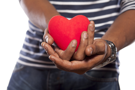 dark-skinned young man holding a heart shaped objectの写真素材