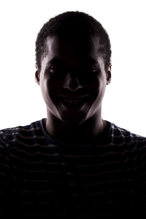 portrait of a smiling african man with his face in shadowの写真素材