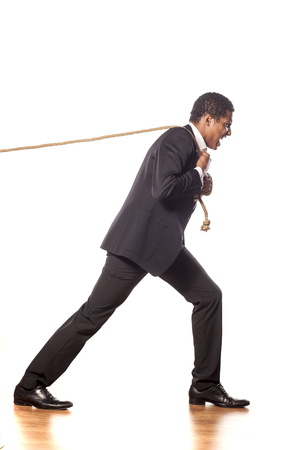 African dark-skinned pulling a rope on white backgroundの写真素材