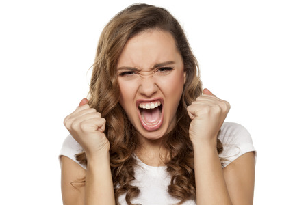 angry and mad pretty girl on a white backgroundの写真素材