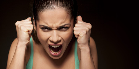portrait of a beautiful angry woman on a dark backgroundの写真素材