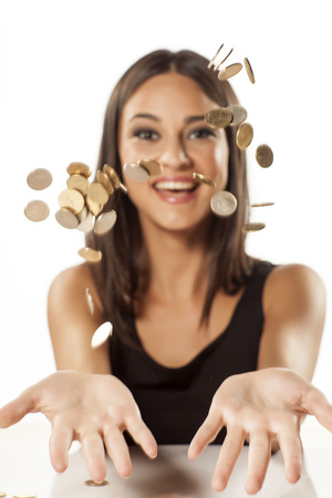 happy attractive girl throwing coins up in the airの写真素材