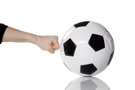 female hand hitting soccer ball with the fistの写真素材