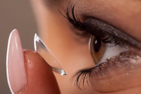Woman putting on contact lenses