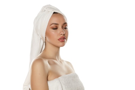 beautiful young woman with a towel on her headの写真素材