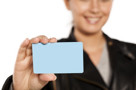 young smiling woman holding a plastic credit card on a white backgroundの写真素材