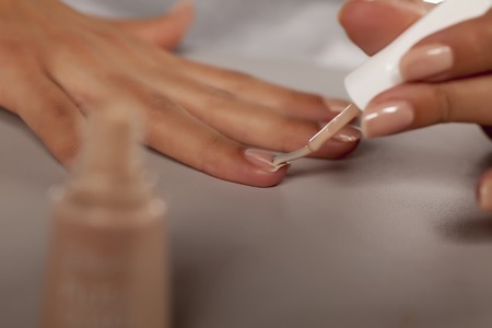 application of nail polish with a brush from the bottleの写真素材