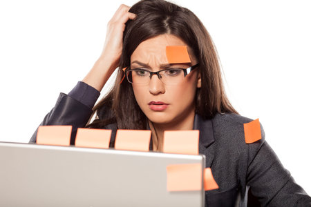 confused young businesswoman with stickers on her and her laptop
