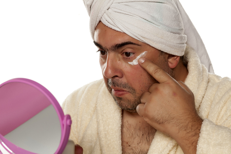 adult man applied the cream under the eyesの写真素材