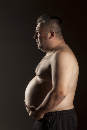 fat shirtless man posing in the studioの写真素材