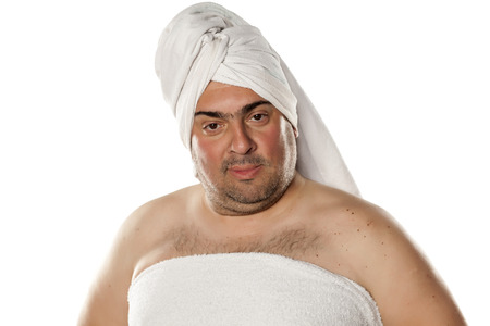 smiling man with a towel on his head on a white backgroundの写真素材