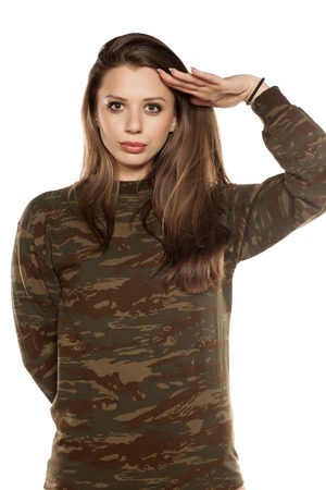 young woman wearing a camouflage blouse and saluteの写真素材