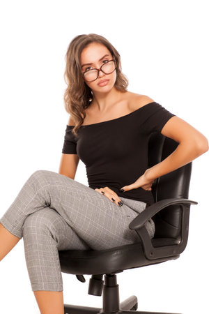 a young serious student with glasses sitting on a chair