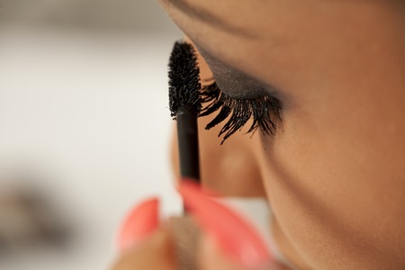 young woman applying a mascara to her eyelashesの写真素材