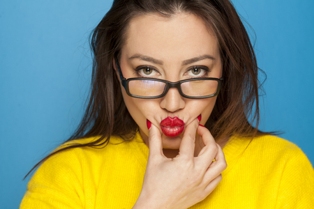 beautiful woman with glasses on blue backgroundの写真素材