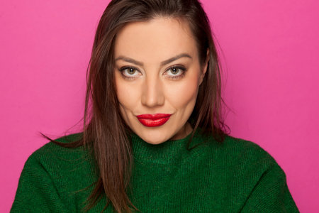 beautiful sexy woman in a green blouse on a pink backgroundの写真素材