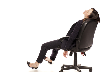 tired businesswoman sleeping in armchair on white backgroundの写真素材