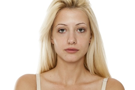 Young blonde woman without makeup on white backgroundの写真素材