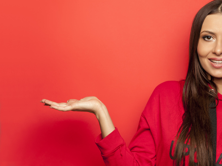 beautiful advertising woman in a red blouse on red backgroundの写真素材