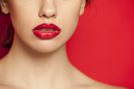 red glossy lipstick on red backgroundの写真素材