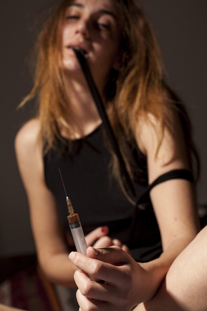 drug addicted girl with a syringe using drugsの写真素材