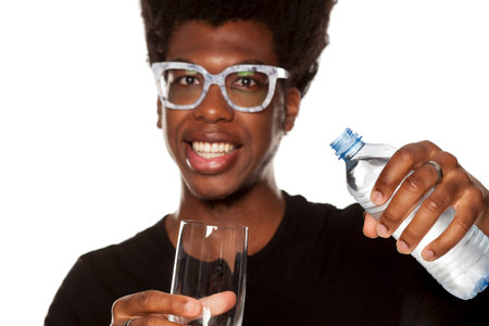 Portrait of young african american man holding  plastic bottle on white background