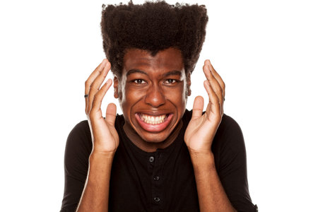 Portrait of young scared african american man  on white backgroundの写真素材