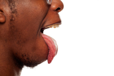 Profile tongue out closeup of young black african american guy on white background