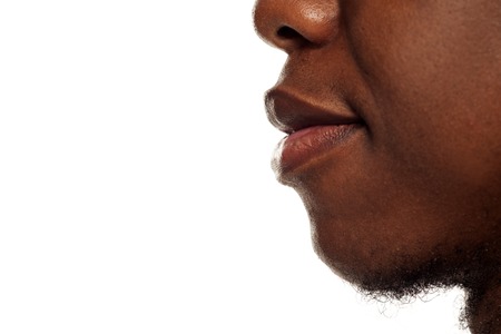 Profile lips closeup of young black african american guy on white backgroundの写真素材