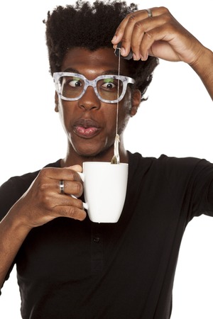Portrait of young african american man holding a mug with tea on white backgroundの写真素材