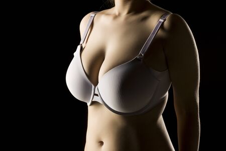 Beautiful big breasts in bra on black backgroundの写真素材