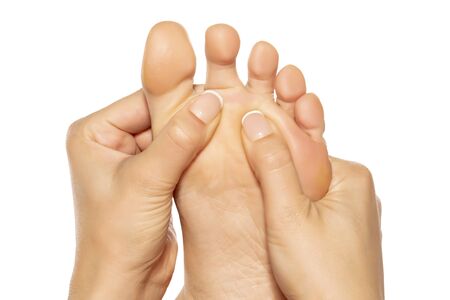woman massaging her painful foot on white backgroundの写真素材