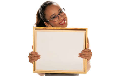 Happy dark skinned woman holding empty whiteboard on white backgroundの写真素材