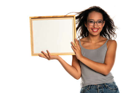Happy dark skinned woman holding empty whiteboard on white backgroundの写真素材