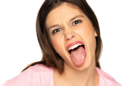portrait of young funny woman with tongue out on white backgroundの写真素材