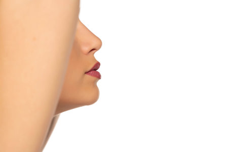 closeup profile, nose and mouth of young beautiful woman on white background