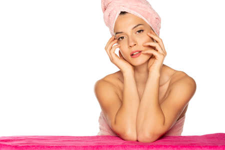 Sensual portrait of beautiful young woman with towel on her head on white backgroundの写真素材