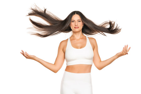 a young beautiful woman throws her long flying hair against a white background