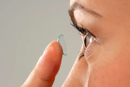 Close-up shot of young woman wearing contact lens. Side view.の写真素材