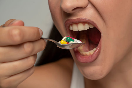 a young woman puts a spoonful of medicine in her mouth