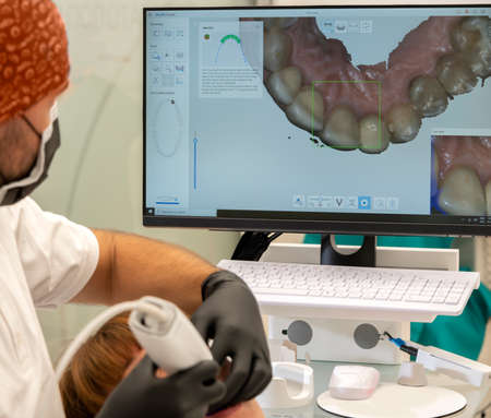 the dentist takes a 3d image on computer  from the patient's mouthの写真素材