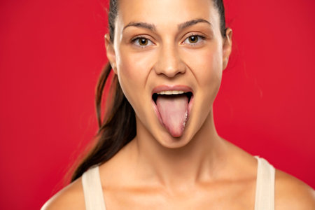Woman sticking up her healthy tongue on a red background