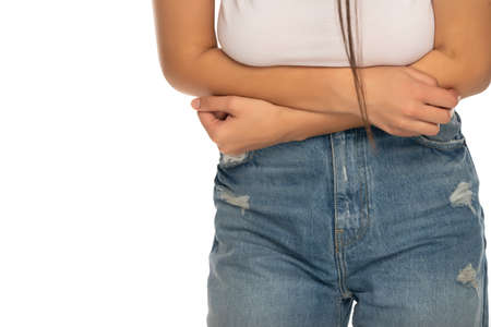 Close up of a woman with abdominal pain on a white backgroundの写真素材