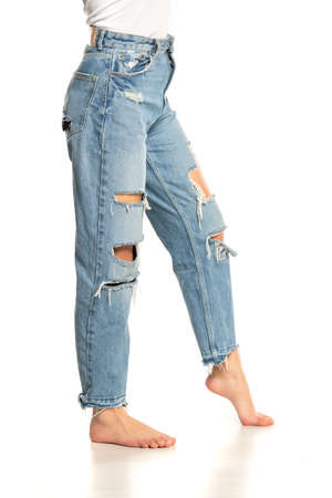 legs of a woman in ripped jeans on a white backgroundの写真素材