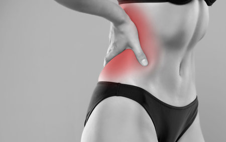woman with pain in the waist and kidneys on a gray background