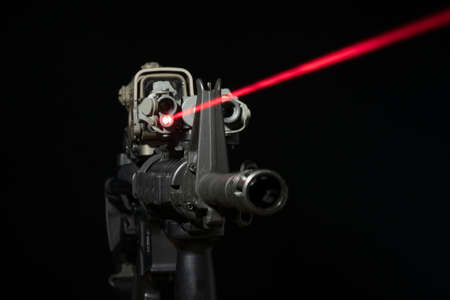 Optical sight and laser device with a red beam on the M4 rifle on dark backgroundの写真素材