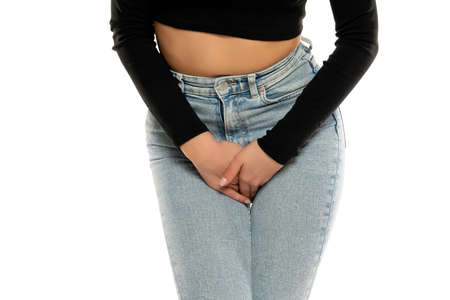 Young woman pressed her hands to the lower abdomen. Medical concept. white backgroundの写真素材