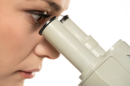 Macro Close Up Shot of a Female Scientist Looking into the Microscope. Side View On A White...
